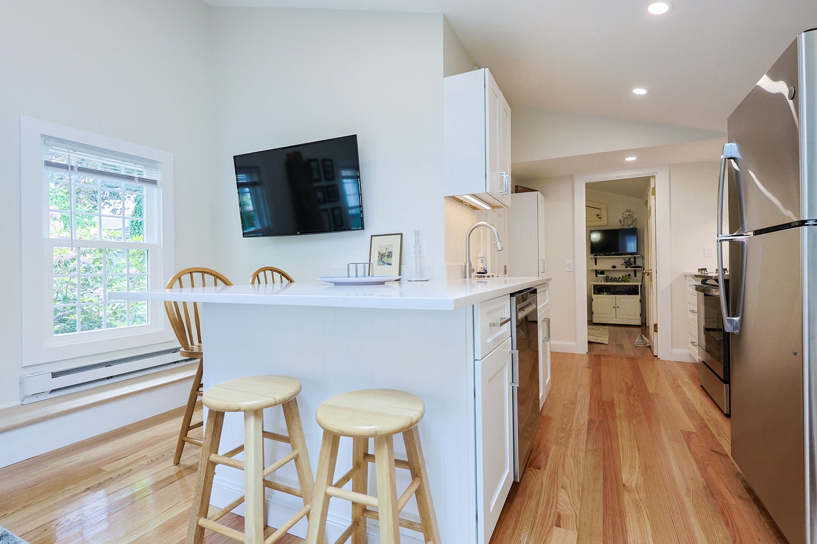 The TV is mounted on the wall near the dining nook.