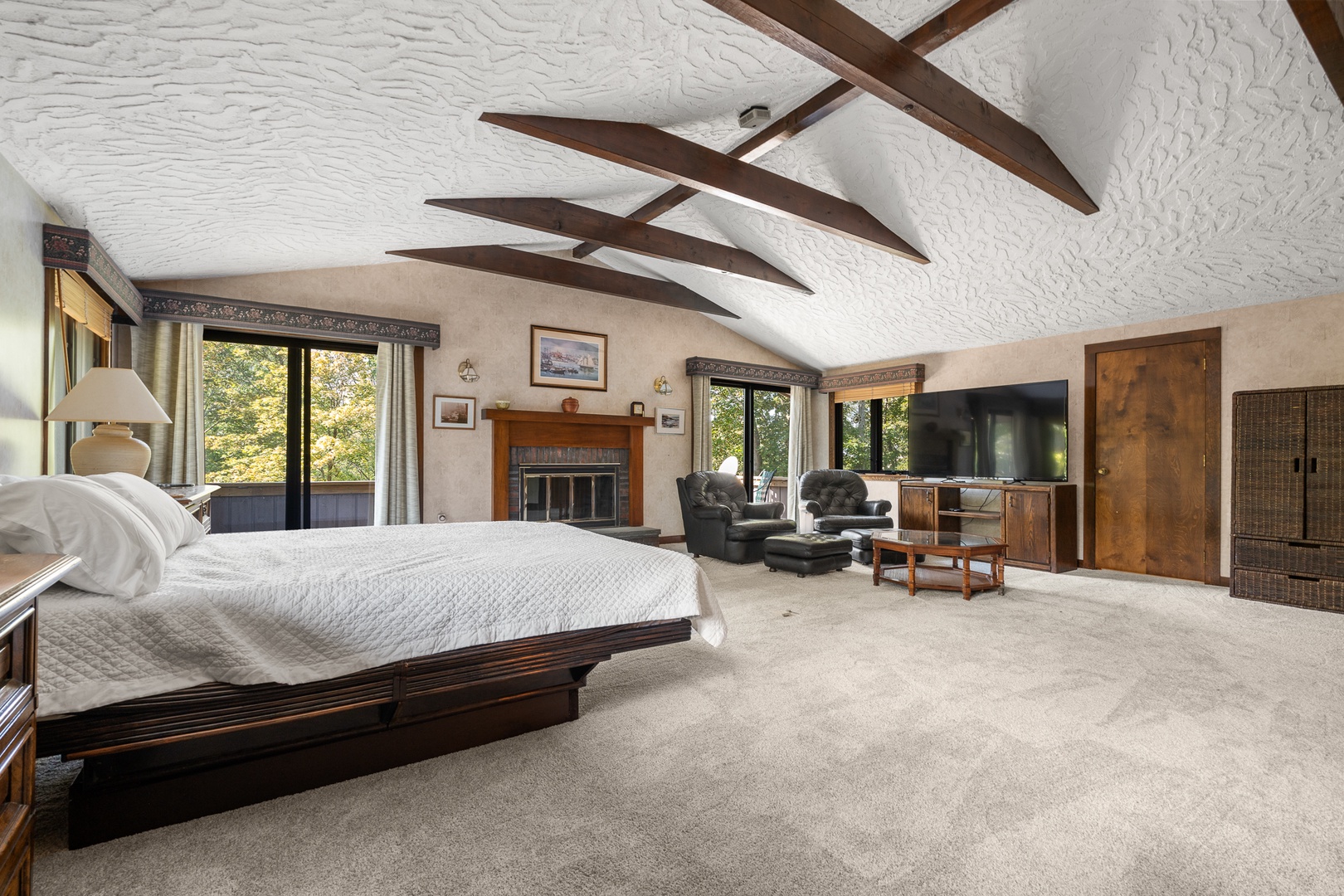 The primary bedroom with a queen bed and a TV lounge on the second floor.