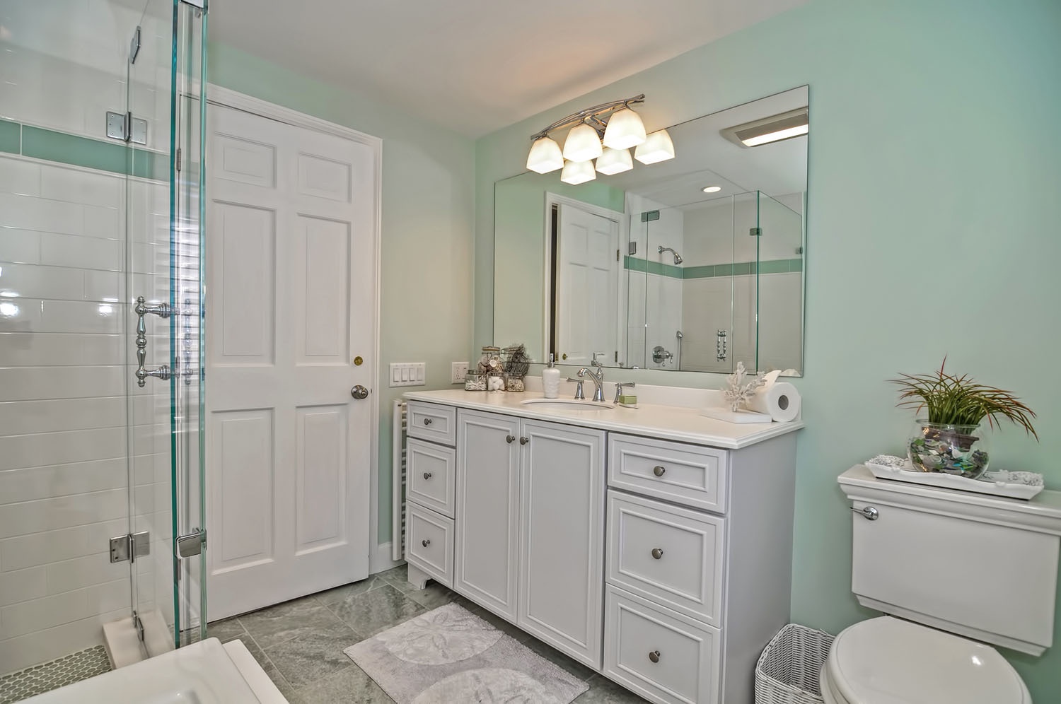 Pamper yourself in this sea-green luxury bath with tiled shower.