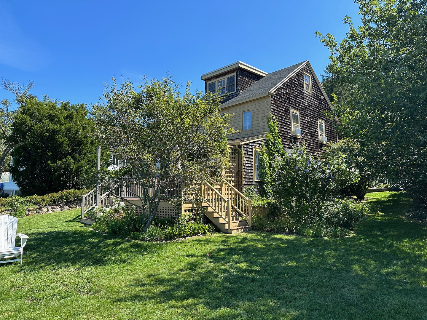 View of the back deck stairs and exterior facade of the home.