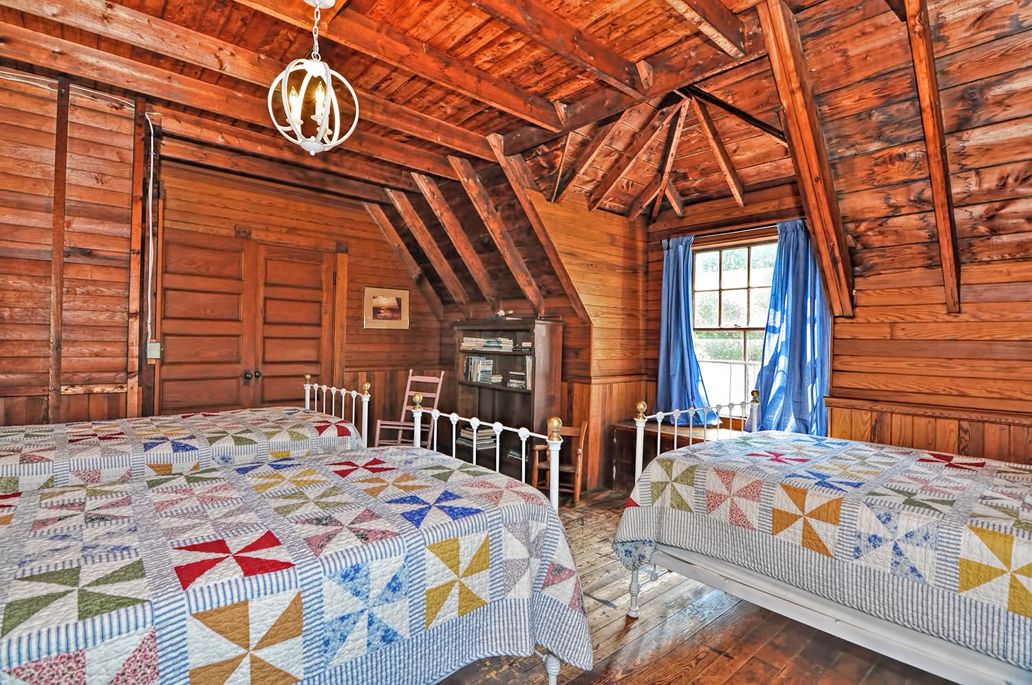 The Camp bedroom has a window seat with a view of the woods.