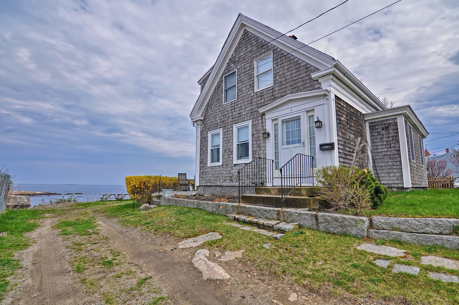 Driveway (unpaved) is in front of the house.