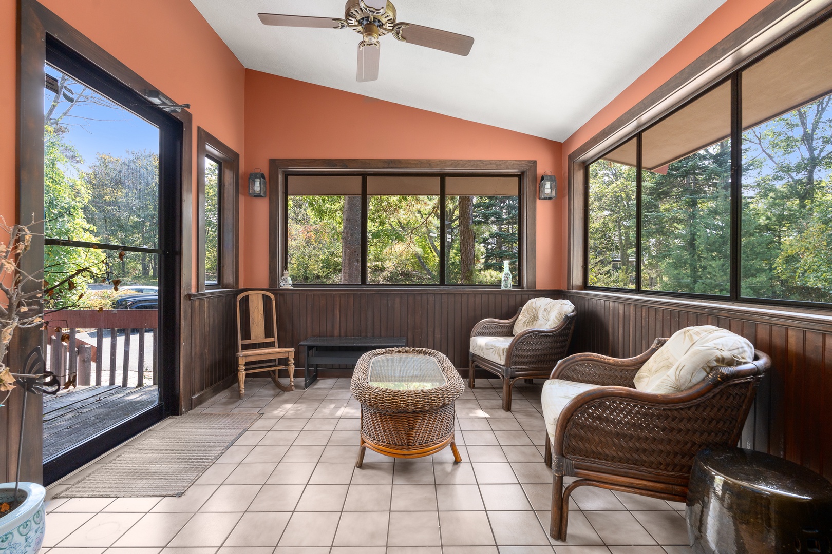 This inviting sun porch is the perfect spot to unwind with a book or simply relax.