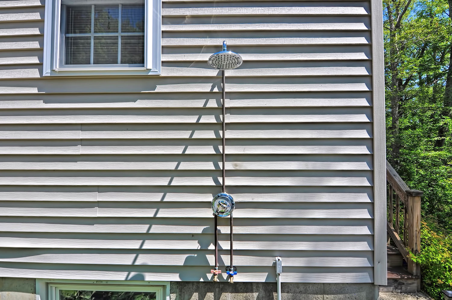 Wash the sand of in the outdoor shower .