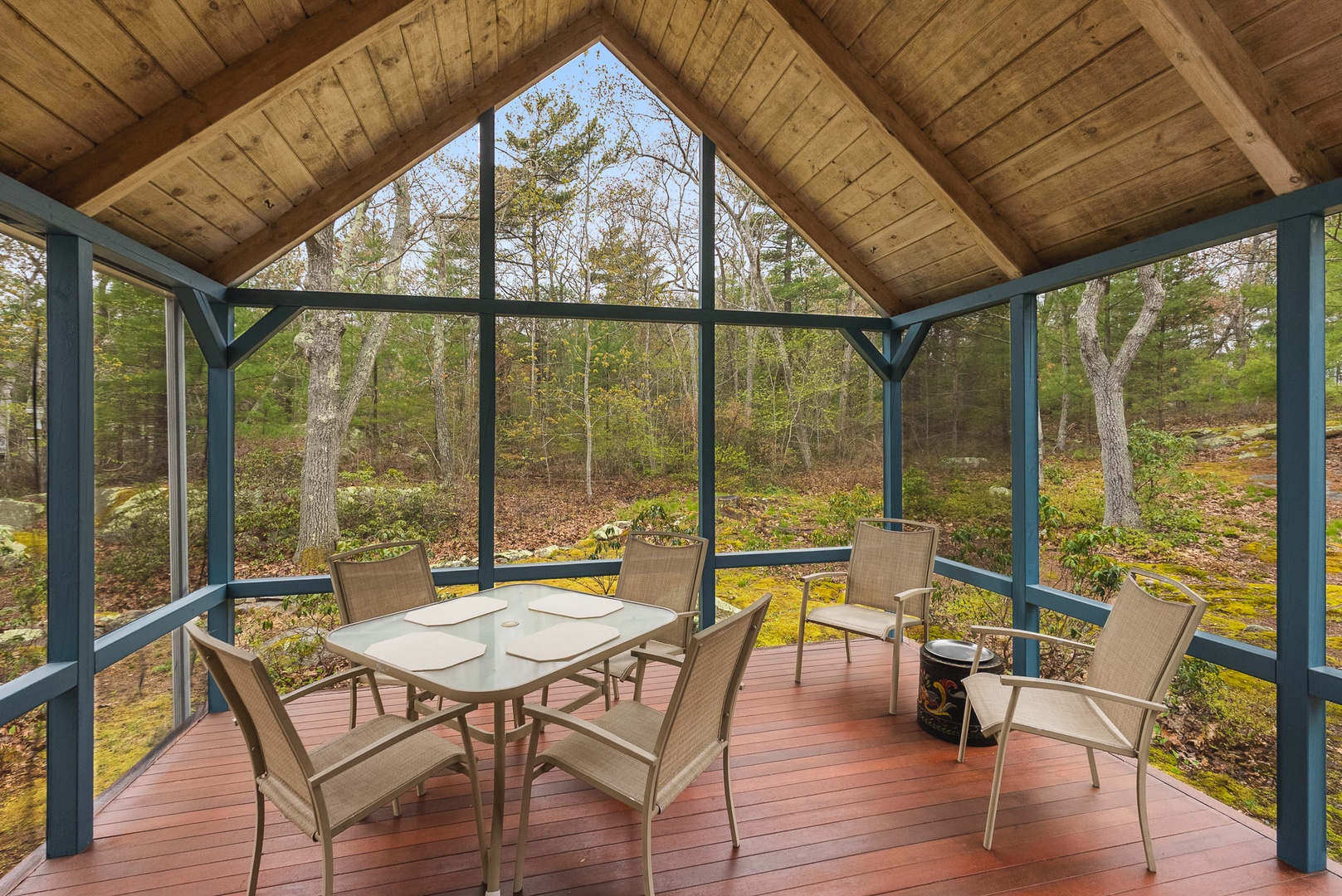 The screened porch is the perfect spot for family meals overlooking the woods.