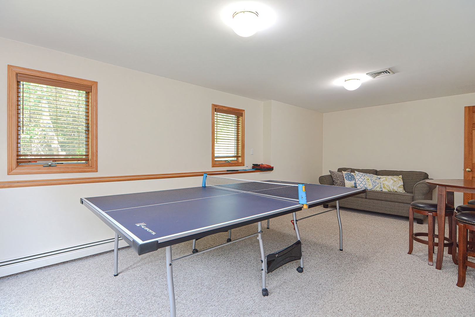 The game room includes a loveseat and bistro table for socializing.