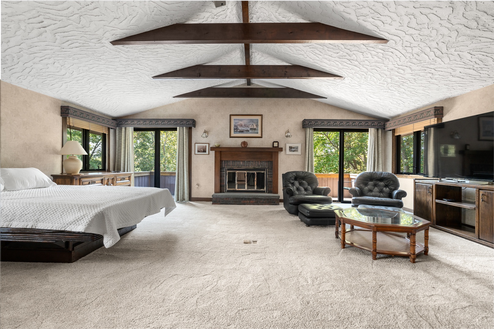 The primary bedroom with a queen bed and a TV lounge.