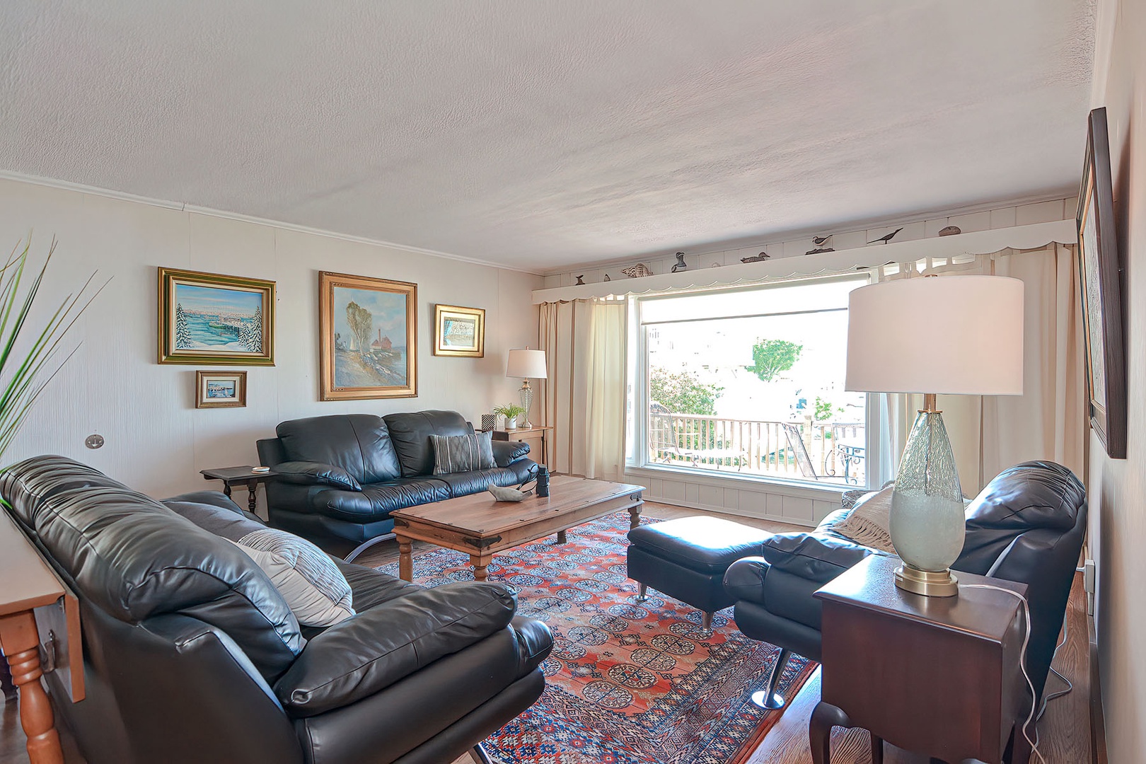 The large living room has comfortable seating and a water view.