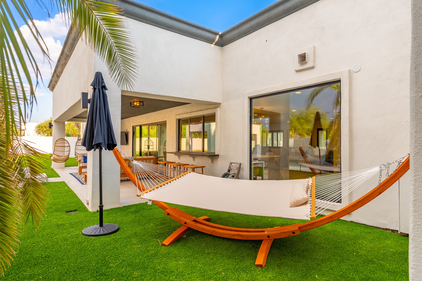 Your private courtyard oasis awaits with a hammock for lazy afternoons, lush palm accents, and seamless indoor-outdoor flow—perfect for unwinding under sunny skies.