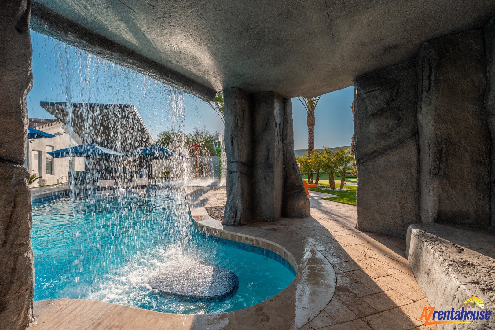 Step into your own private grotto where cascading water creates a soothing symphony around this stunning pool sanctuary.
