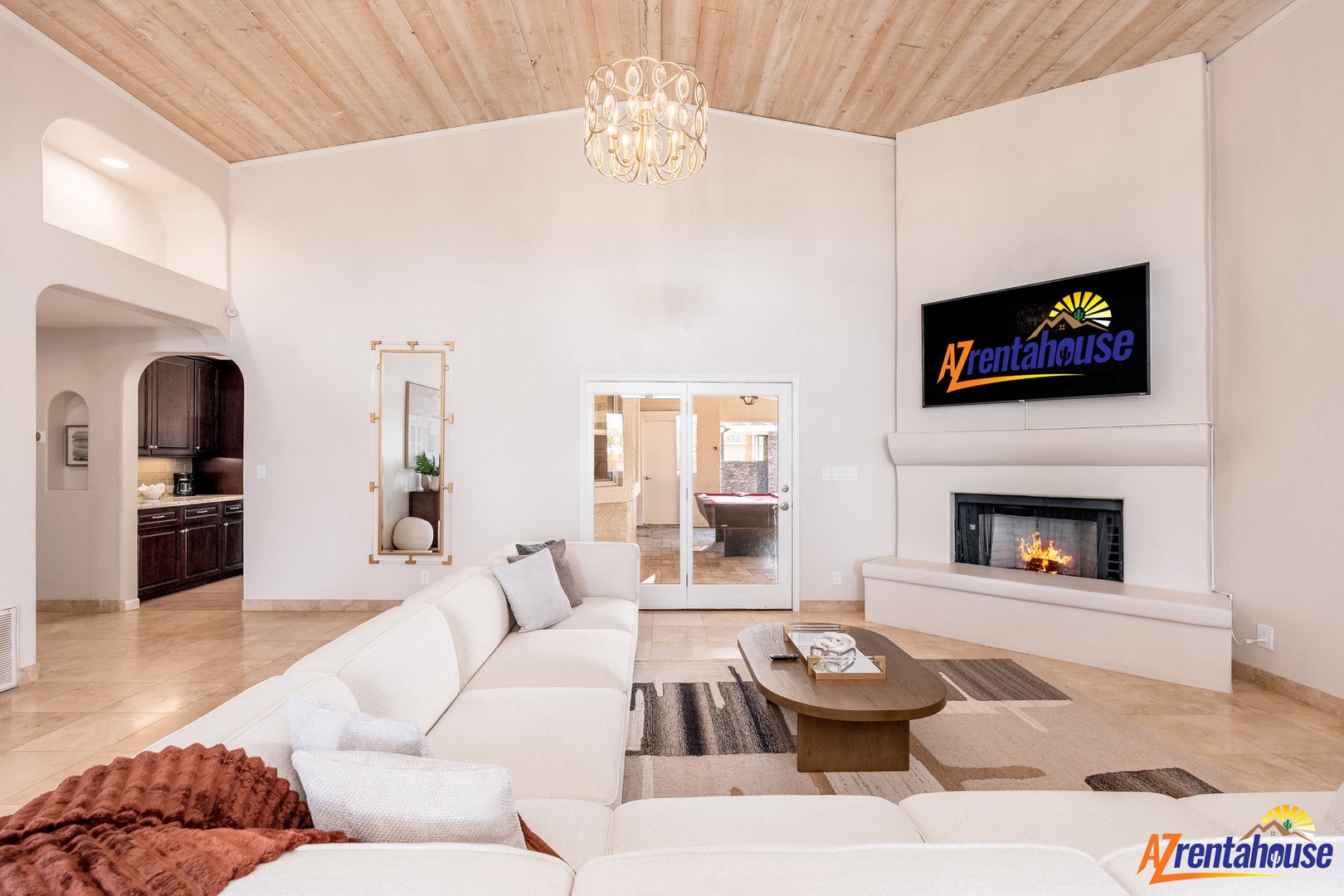 Settle into plush seating by the cozy fireplace, where soaring wood ceilings and natural light create your perfect retreat after a day of desert adventures.