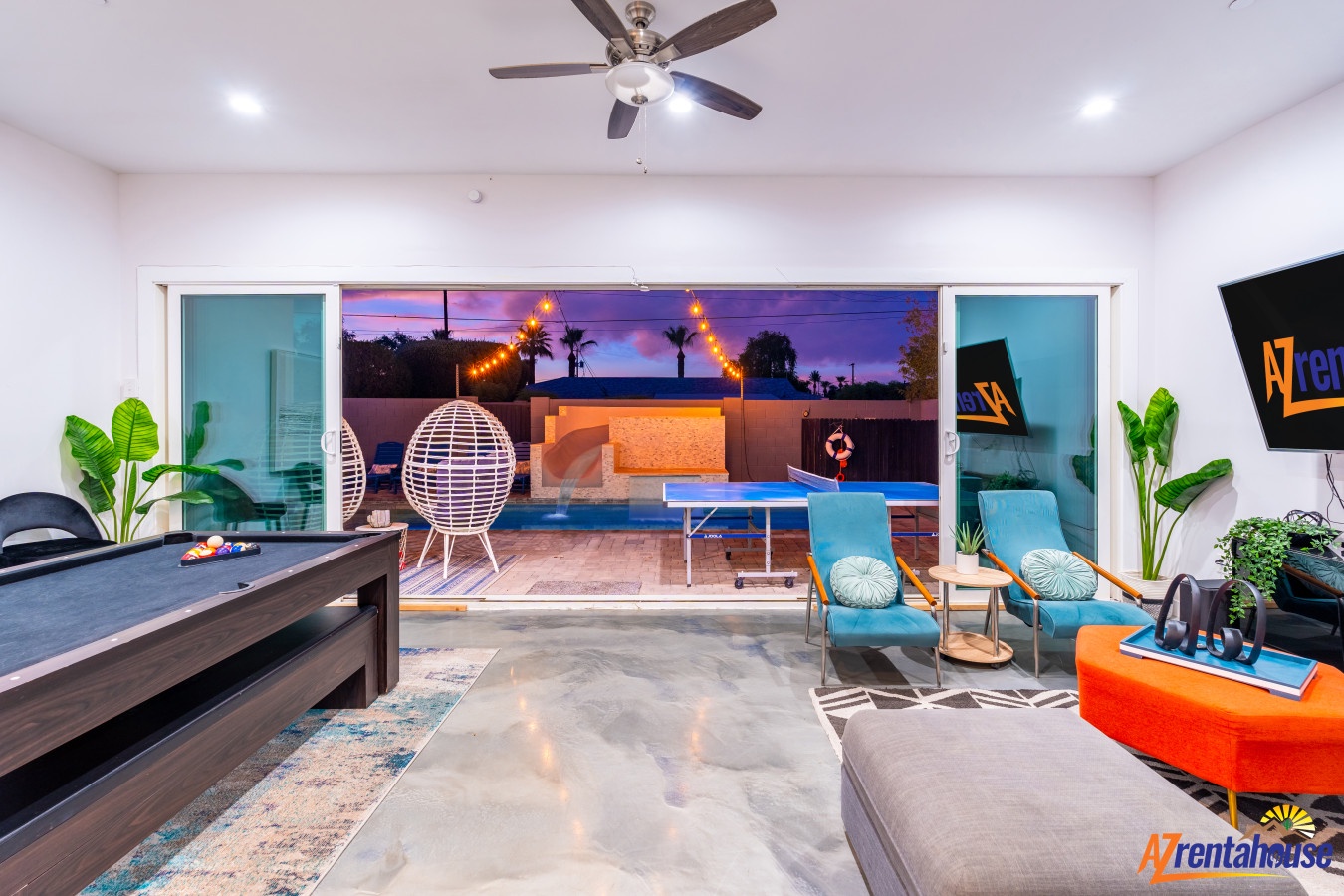 Unwind in your stylish living space with direct pool access through sliding glass doors. The modern furnishings and entertainment setup create the perfect evening retreat.