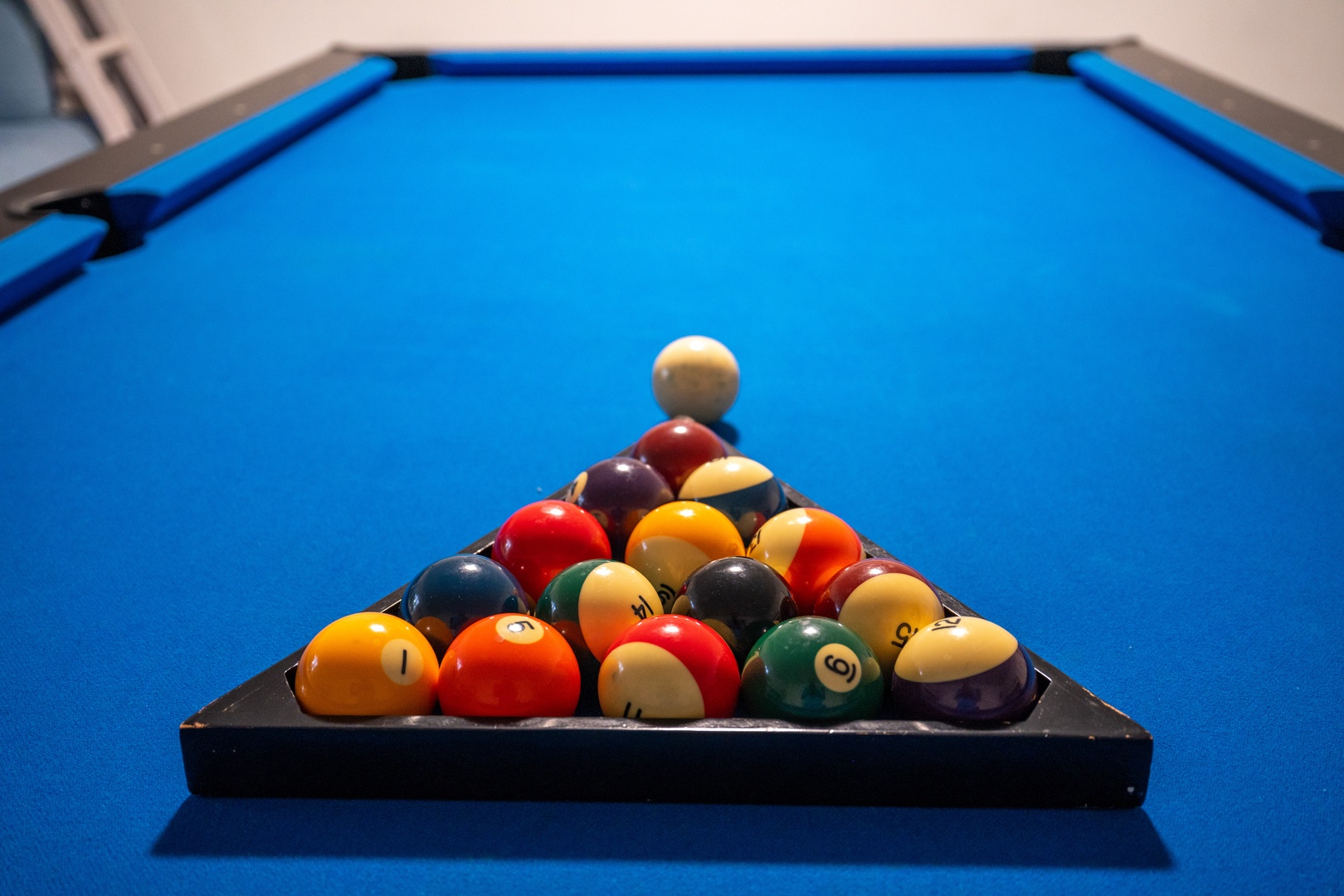 Challenge friends to a game on this pristine billiard table, where vibrant balls wait ready for your next competitive match or leisurely evening of fun.