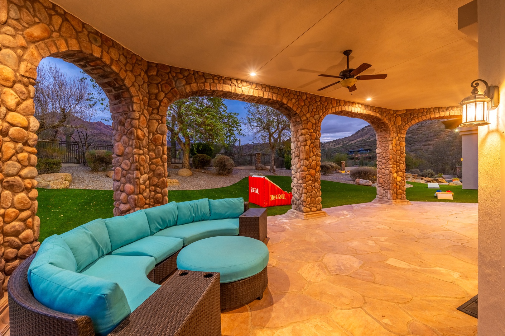 Unwind in your private covered patio with stunning mountain views, perfect for evening relaxation under the desert sky with plush seating and ambient lighting.