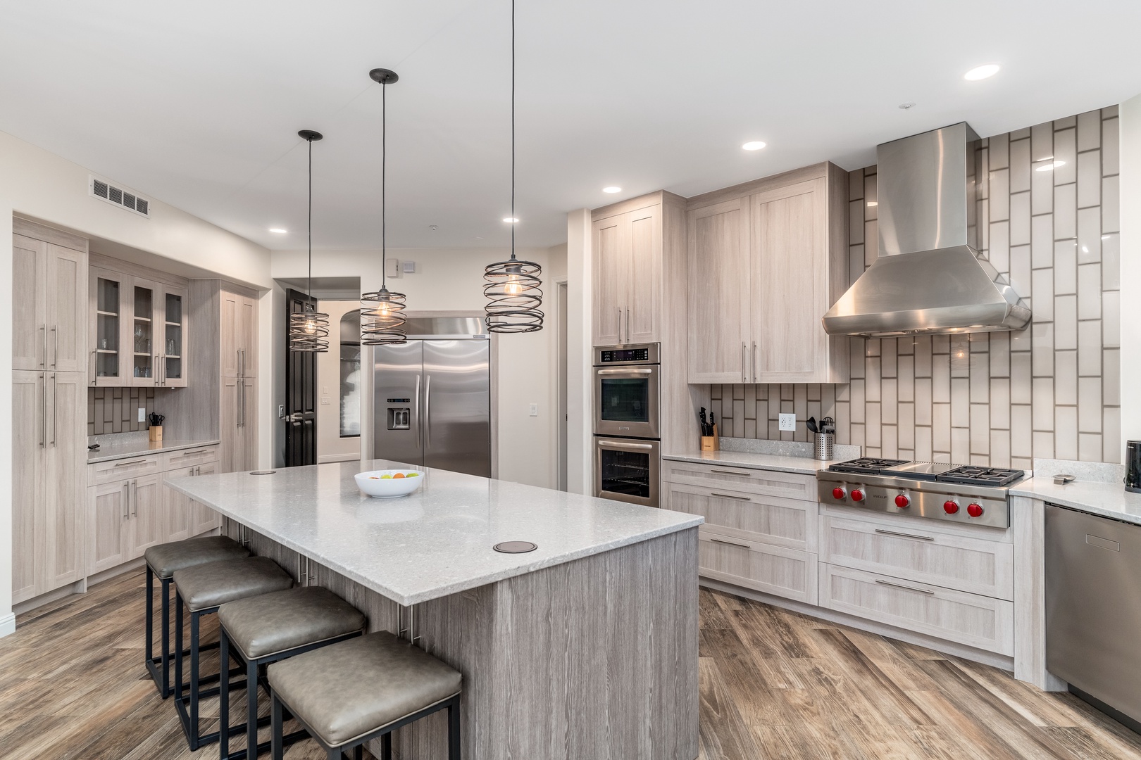 Your fully equipped gourmet kitchen awaits with sleek stainless steel appliances, spacious countertops, and a large island perfect for preparing meals and gathering together.