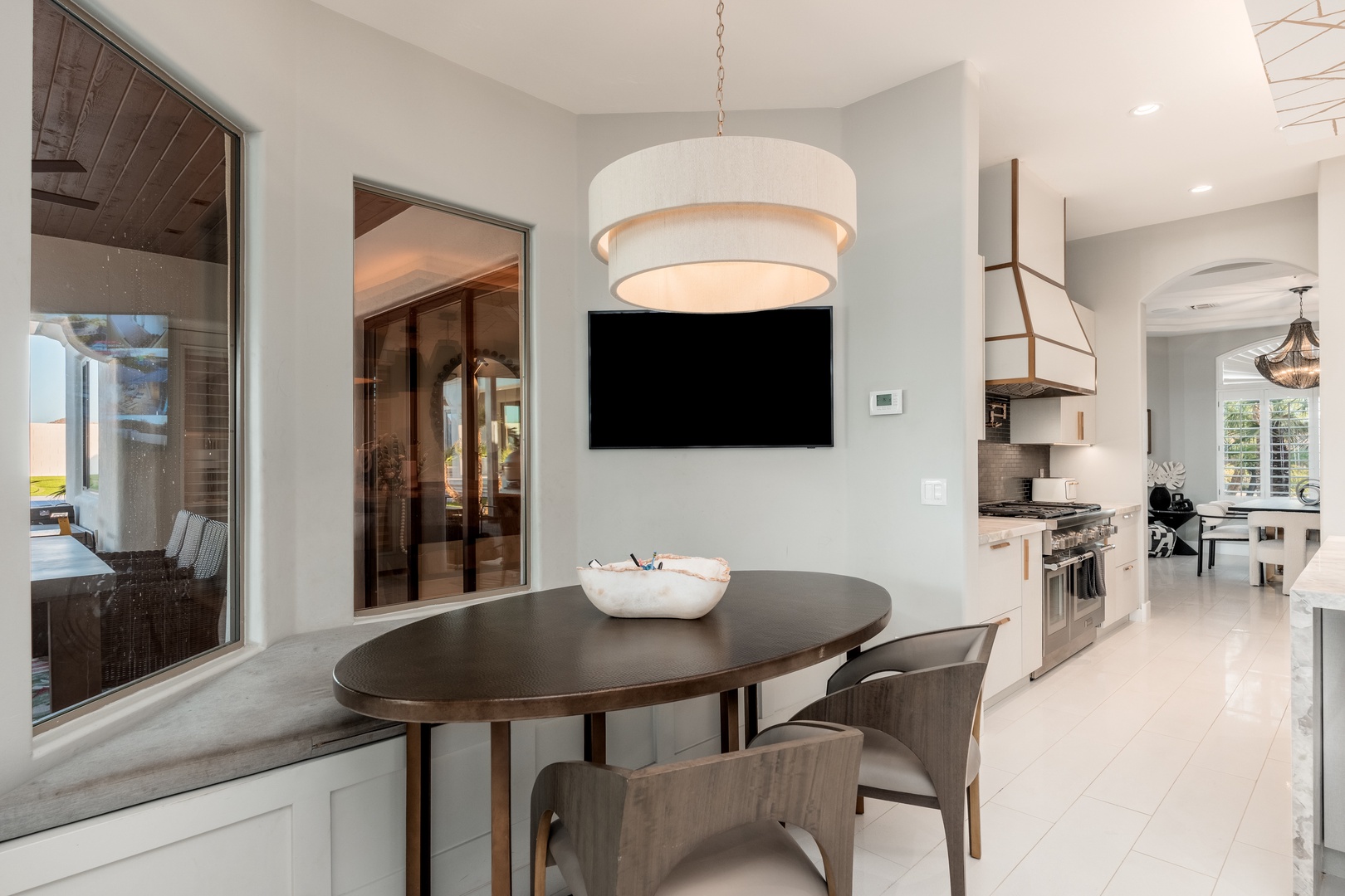Picture yourself savoring morning coffee at this elegant oval table, bathed in natural light. The open layout flows seamlessly into a modern kitchen, while outdoor views invite relaxation.