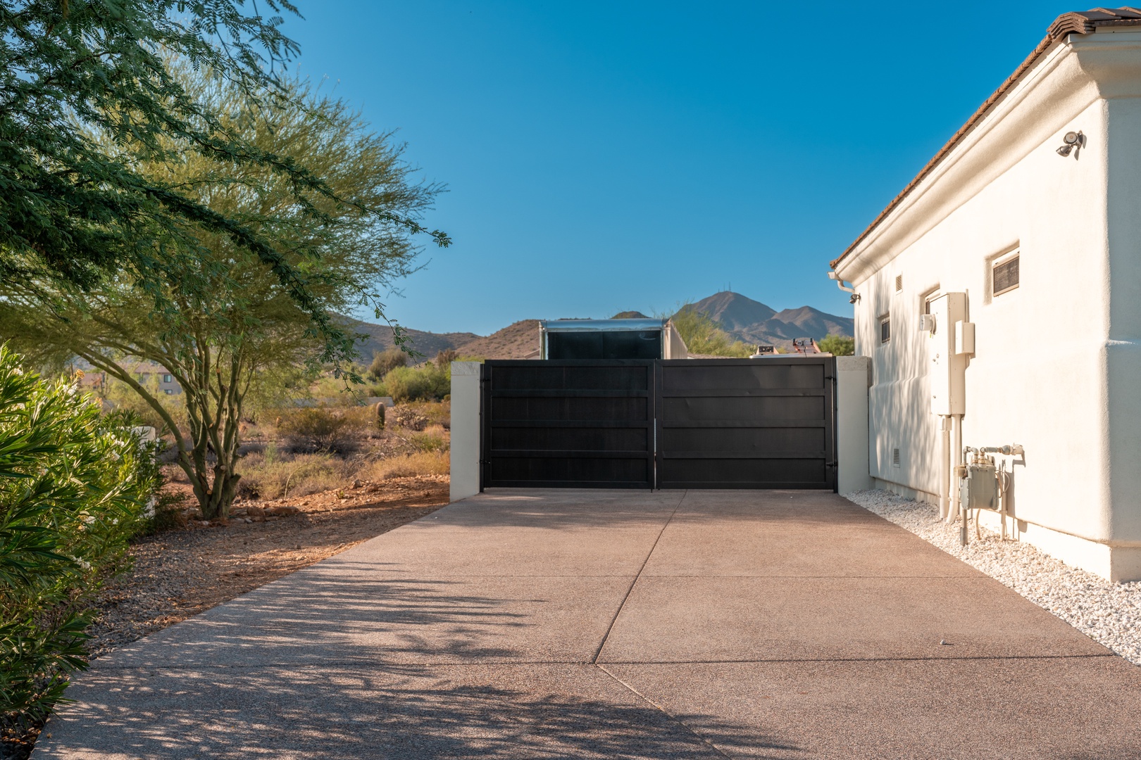 This desert retreat features modern architecture framed by natural desert landscaping and striking mountain views, offering a private escape in a scenic setting.
