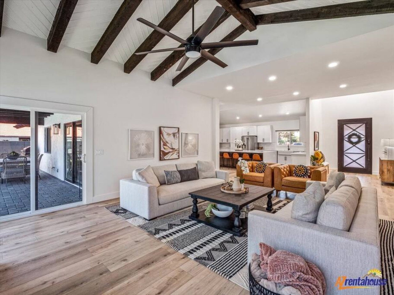 Unwind in your spacious living room featuring rustic beams, plush seating, and an open flow to your fully equipped kitchen.