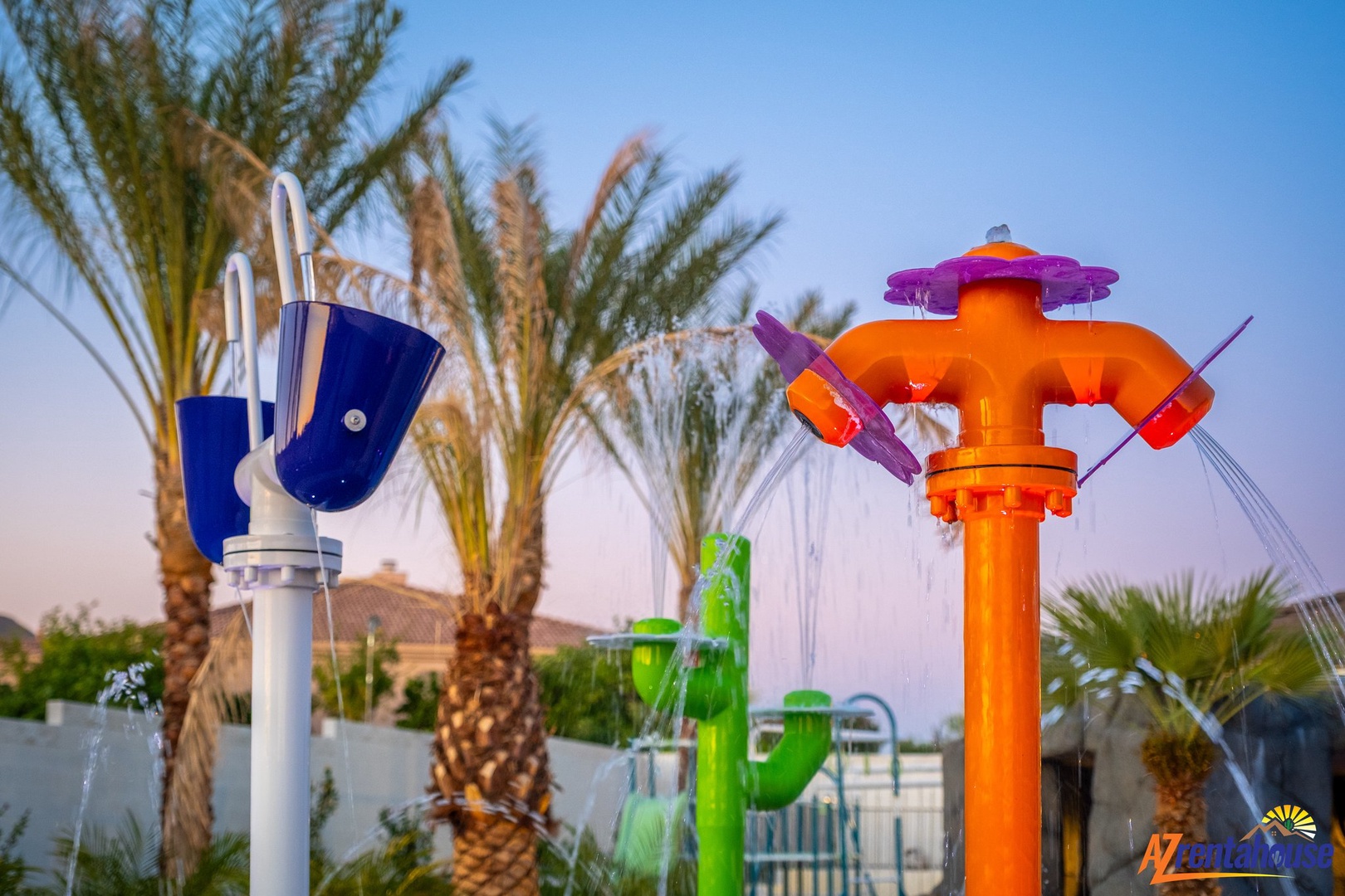 Colorful water play features create a fun splash zone surrounded by tropical palms.