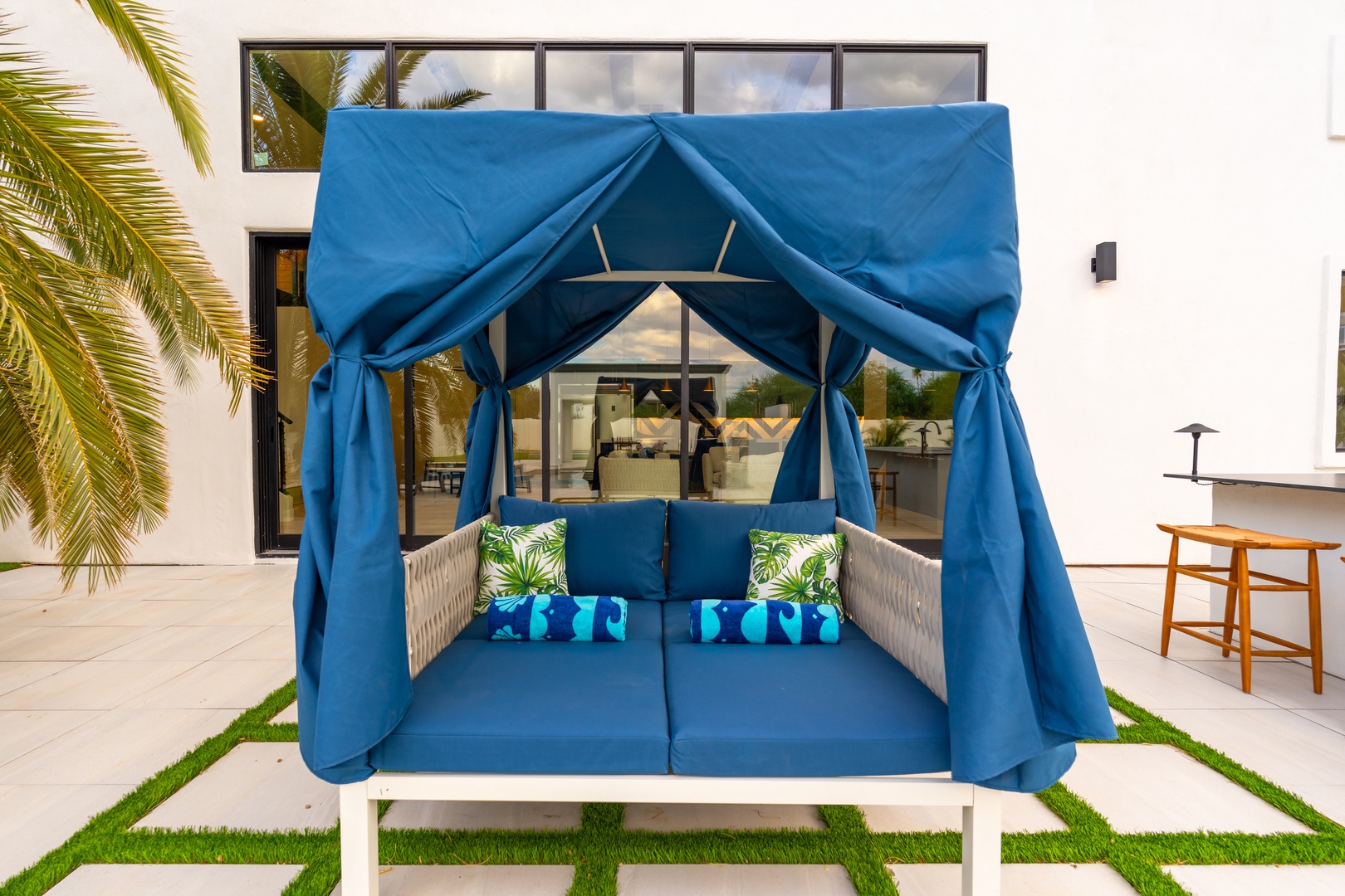 Sink into plush cushions beneath your private cabana, surrounded by swaying palms and modern elegance—your perfect spot to unwind with a book or afternoon nap.