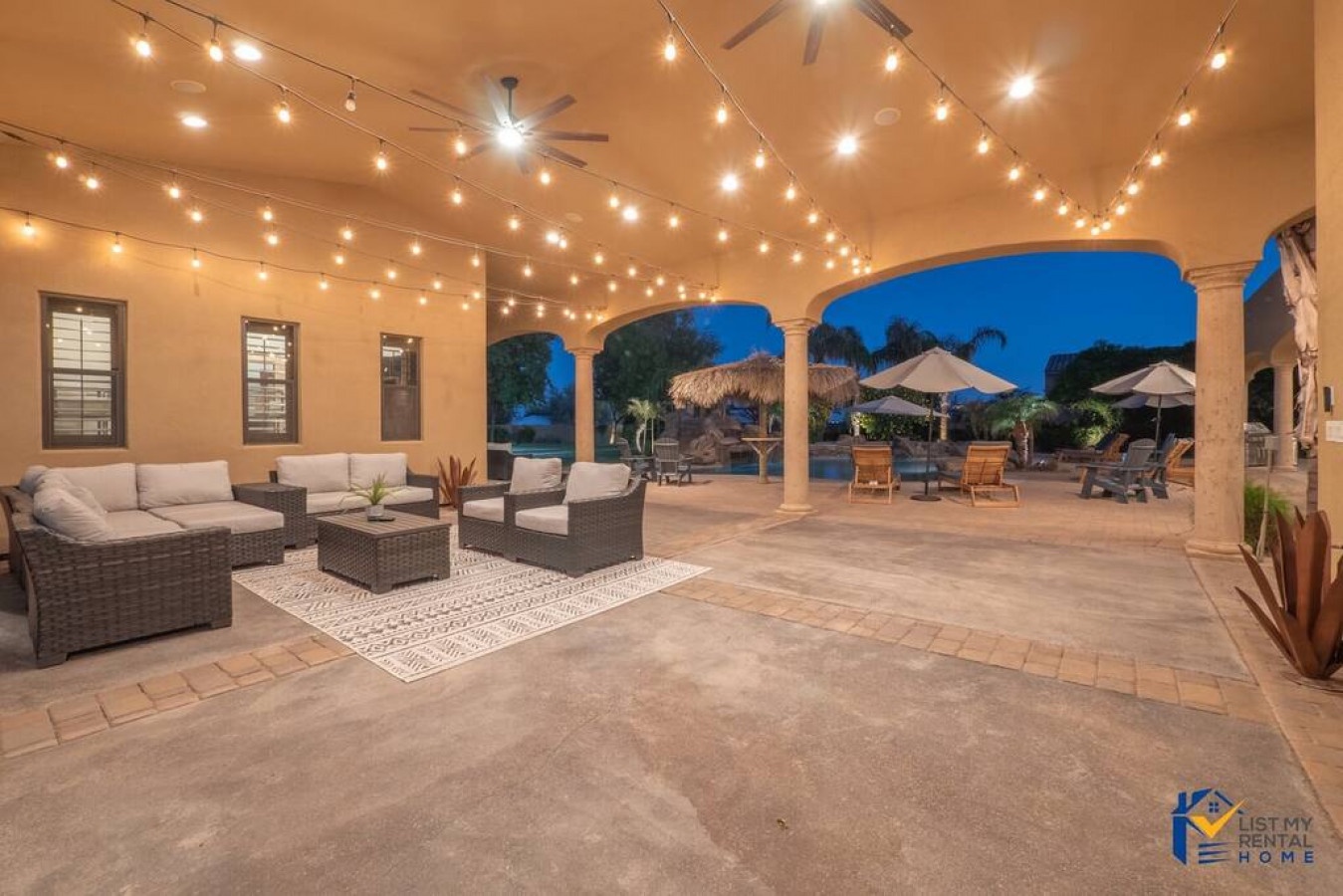 Unwind under twinkling string lights in your expansive covered patio, where plush seating and tropical breezes create the perfect evening retreat.