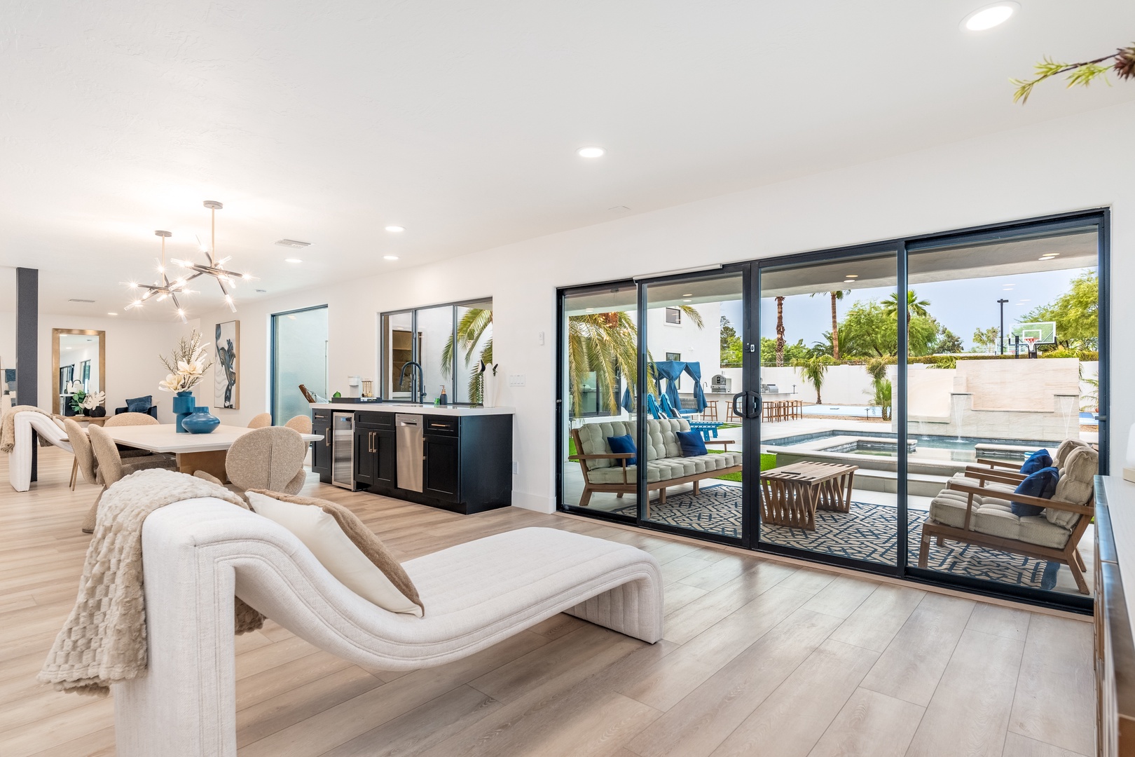Modern open-plan living flows seamlessly to your private pool oasis through expansive glass doors, blending indoor comfort with sunny outdoor relaxation.