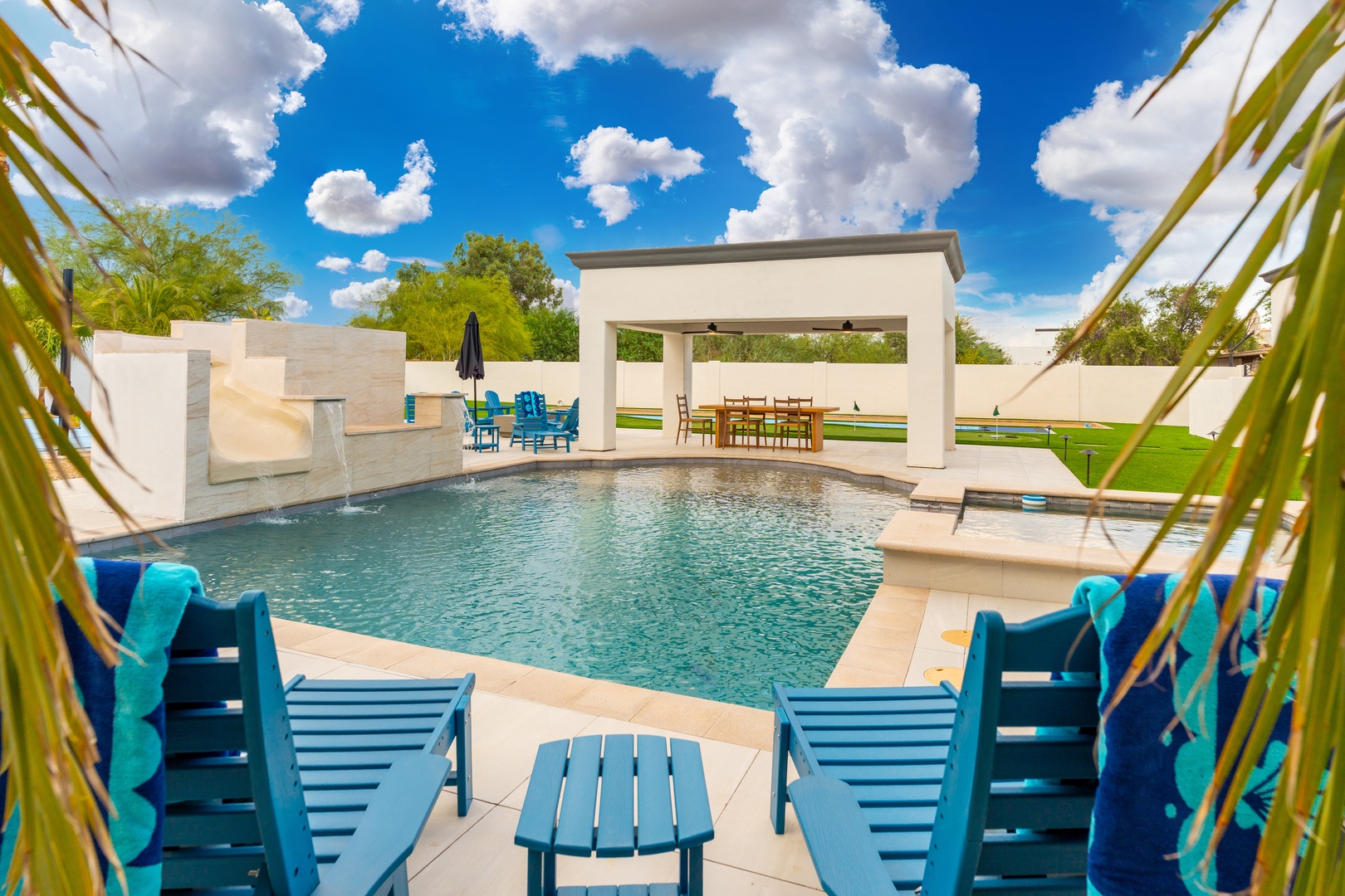 Imagine lounging by your private pool, soaking up sunshine under bright desert skies. Splash in cool water, dine under the covered cabana, and unwind in vibrant turquoise chairs with towels ready.
