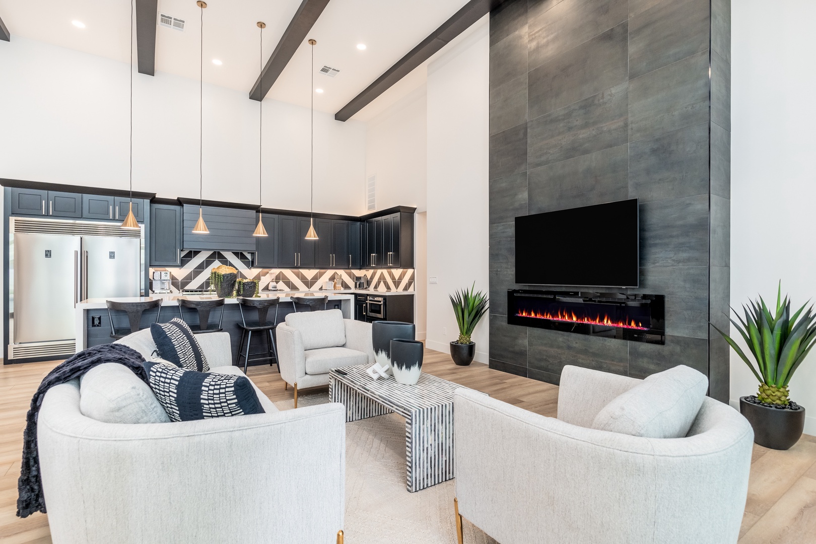 Unwind in your open-concept living space with soaring ceilings, sleek modern design, and a cozy electric fireplace that sets the mood for relaxing evenings together.