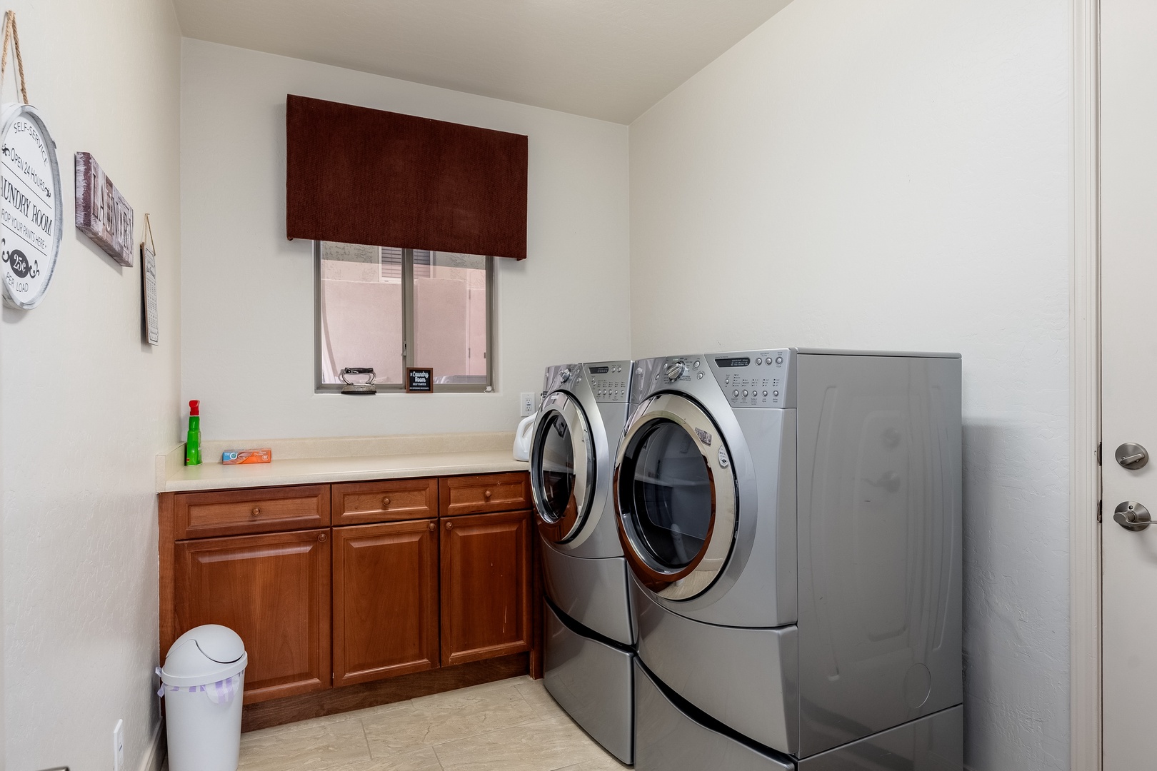 Keep your wardrobe fresh with ease in this well-equipped laundry room, featuring a full-size washer and dryer, plus convenient countertop space for folding.