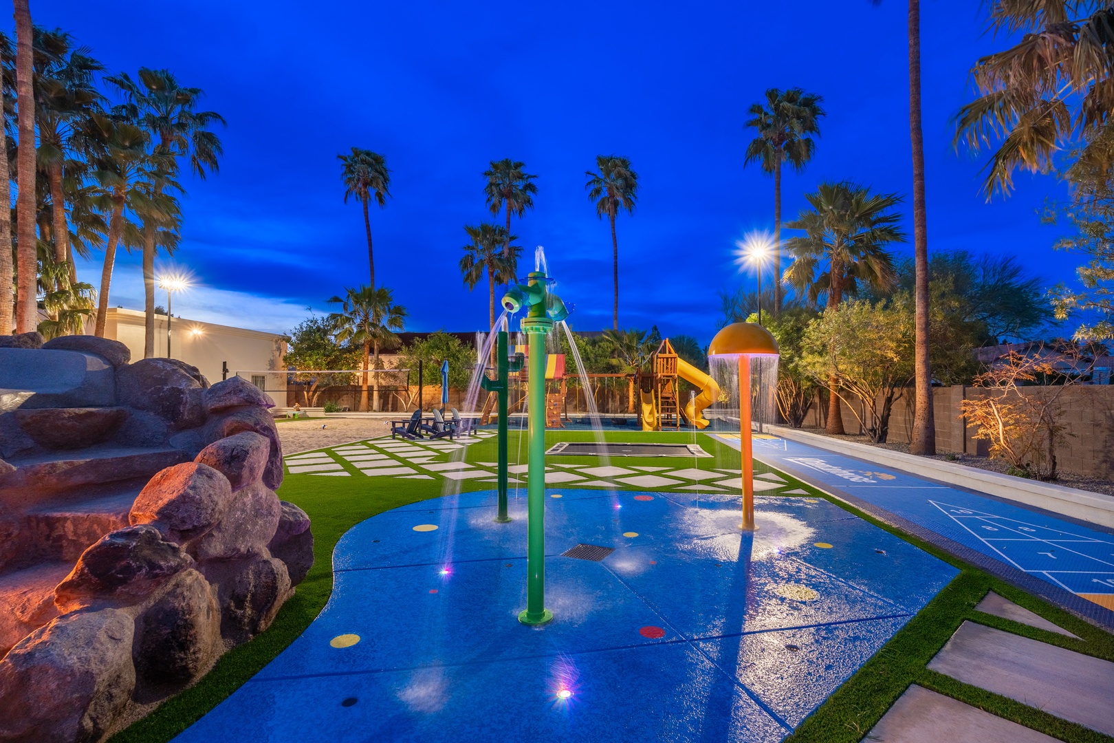 A vibrant splash pad and playground features colorful water jets, slides, and climbing structures—ideal for active kids and sunny afternoons.