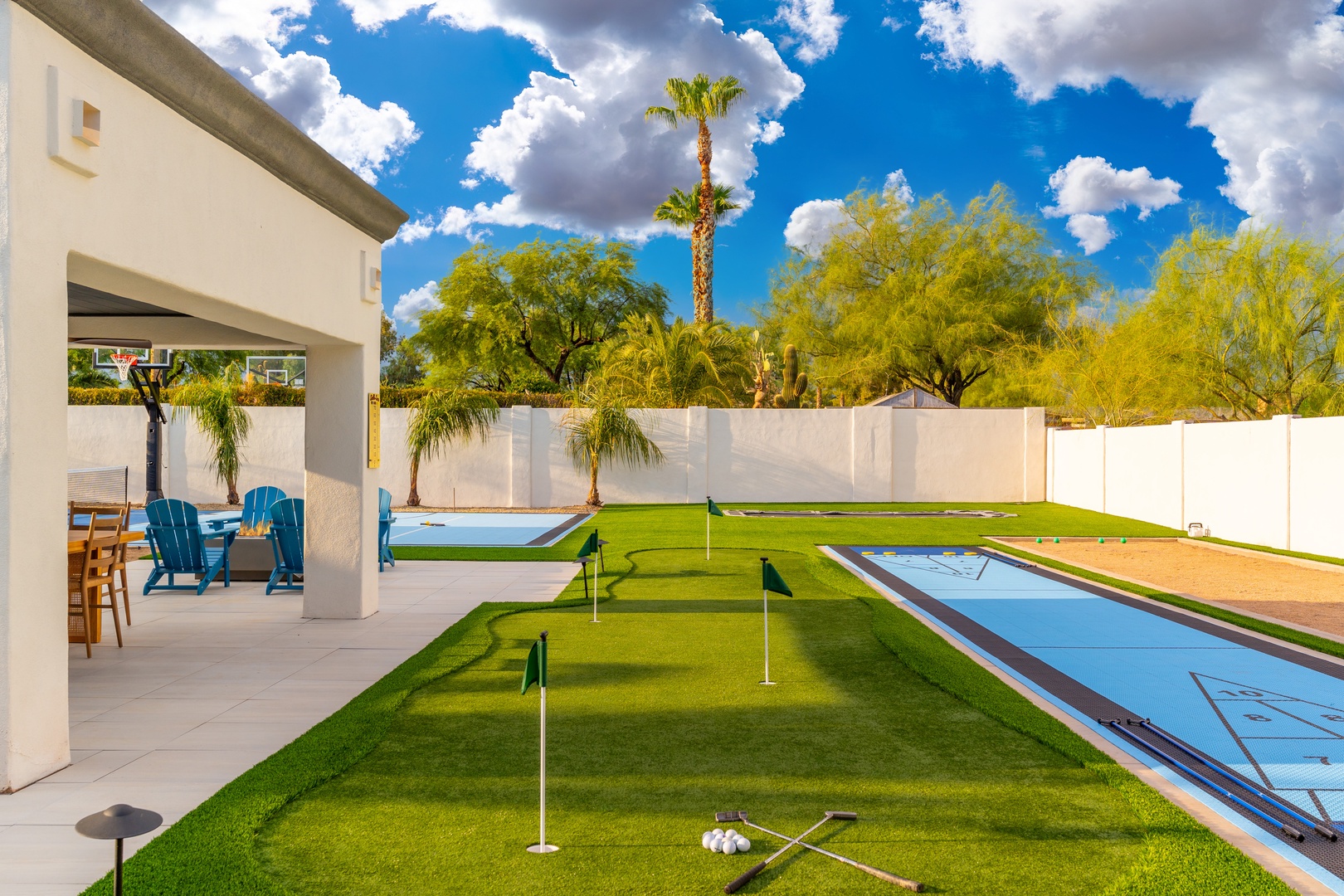 Sunny Arizona getaway with private putting green, blue shuffleboard courts, and covered patio seating—perfect for outdoor fun under desert skies.