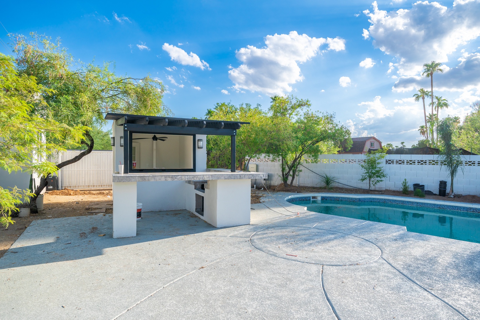 Modern outdoor oasis with private pool, shaded poolside bar, and palm-studded views under wide Arizona skies—perfect for sunny afternoons and alfresco entertaining.