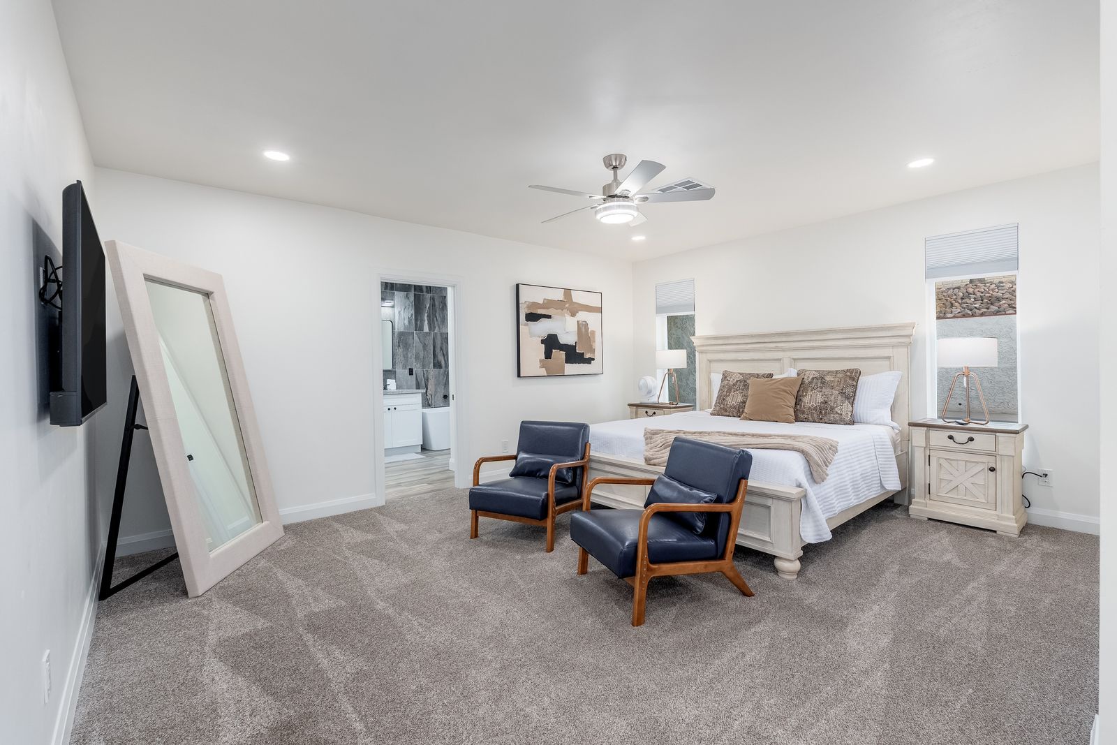 Unwind in your spacious master suite with plush bedding, chic seating, and modern artwork. Large windows let in natural light, while the ceiling fan keeps you comfortable year-round.