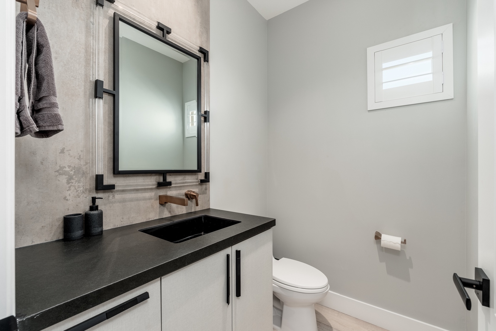 Step into a sleek, modern bathroom where warm wood tones meet cool concrete textures. Soft towels await your use as natural light filters through the window, creating a spa-like retreat.