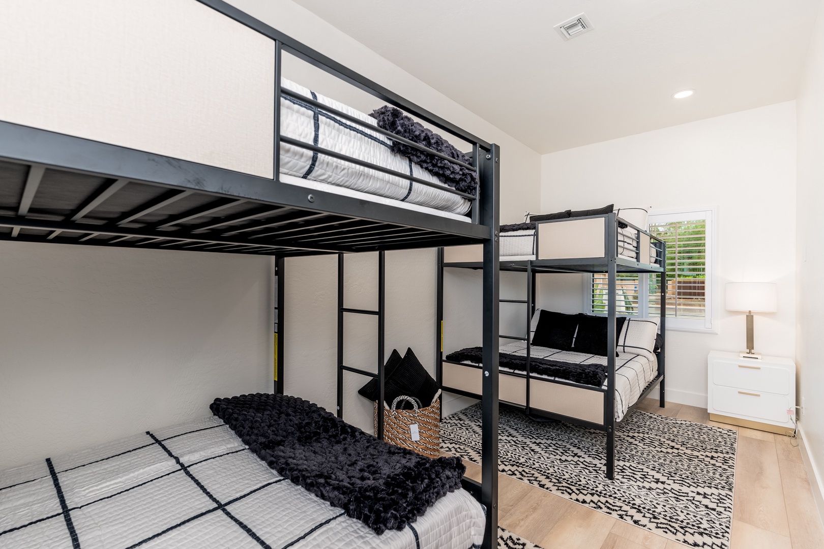 Your crew will love this stylish bunk room with cozy bedding and modern black metal frames. Perfect for families or groups traveling together, with natural light and plenty of space.
