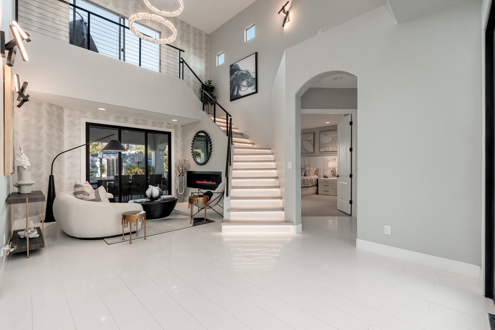 Step into soaring two-story ceilings with sleek modern finishes, gleaming tile floors, and a designer fireplace that makes this open-concept space feel instantly luxurious and welcoming.