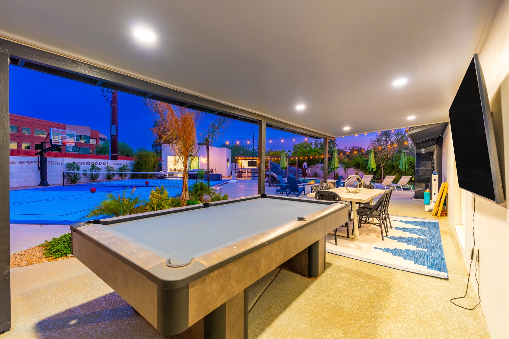Challenge your friends to a game of pool in your stylish indoor-outdoor entertainment space with glowing evening views of the pool and patio.