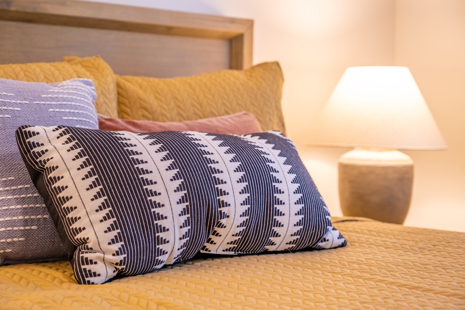 Sink into plush comfort with textured pillows and soft bedding that invite you to relax. The warm glow of the bedside lamp creates a cozy retreat for restful nights.