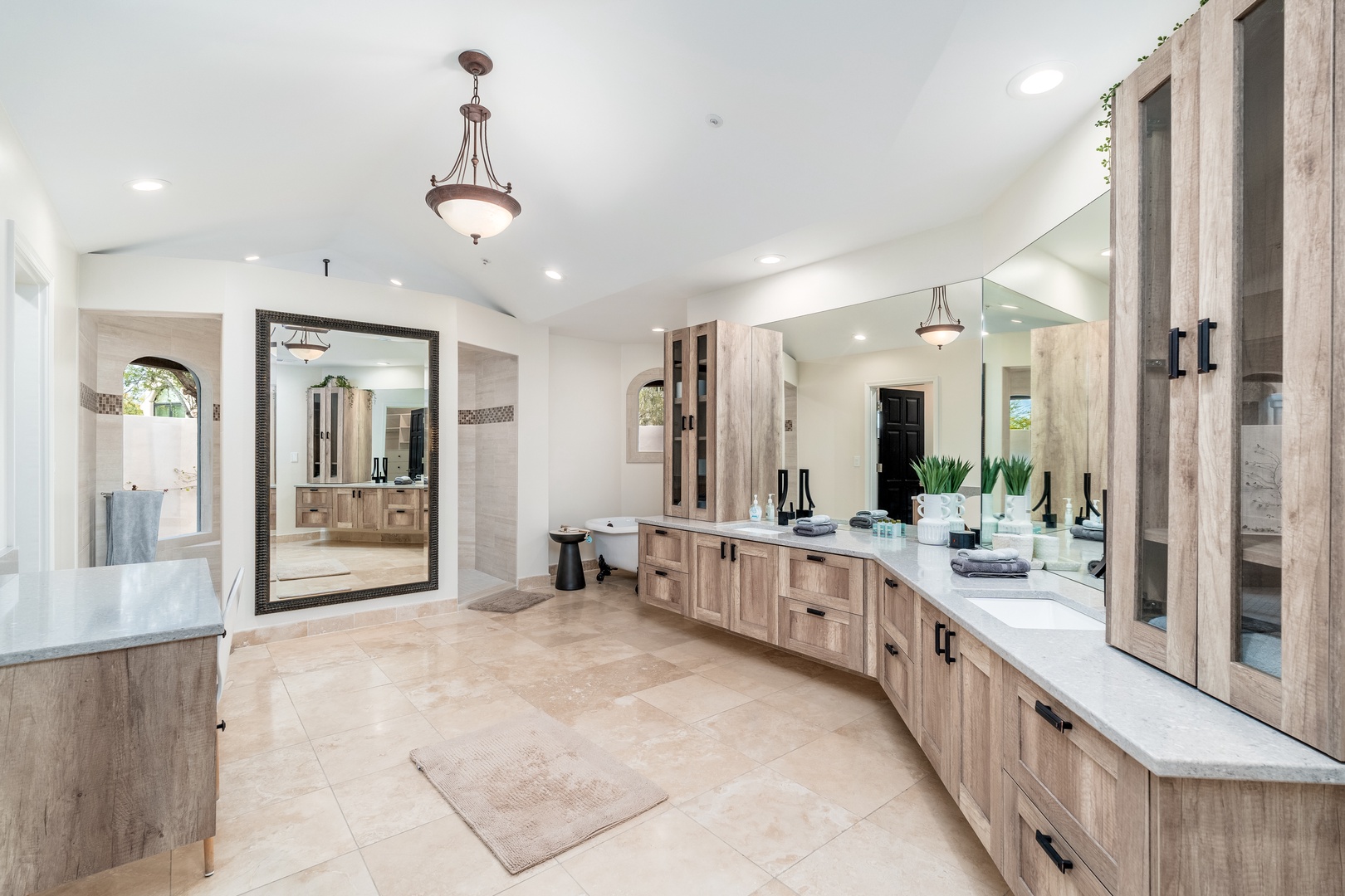 Step into your luxurious spa-like bathroom with dual sinks, elegant wood cabinetry, and a spacious soaking tub waiting for your relaxation.