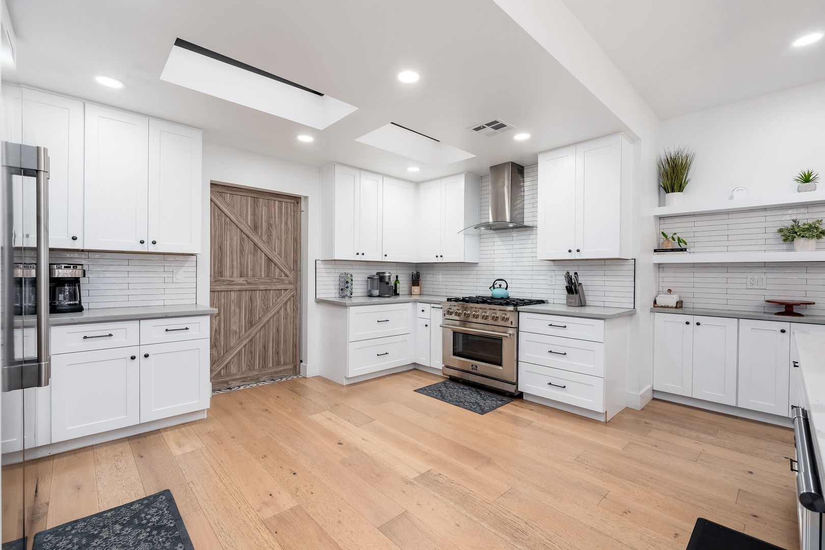 Picture yourself preparing meals in this bright, spacious kitchen with sleek white cabinetry, modern stainless appliances, and abundant counter space for all your culinary adventures.