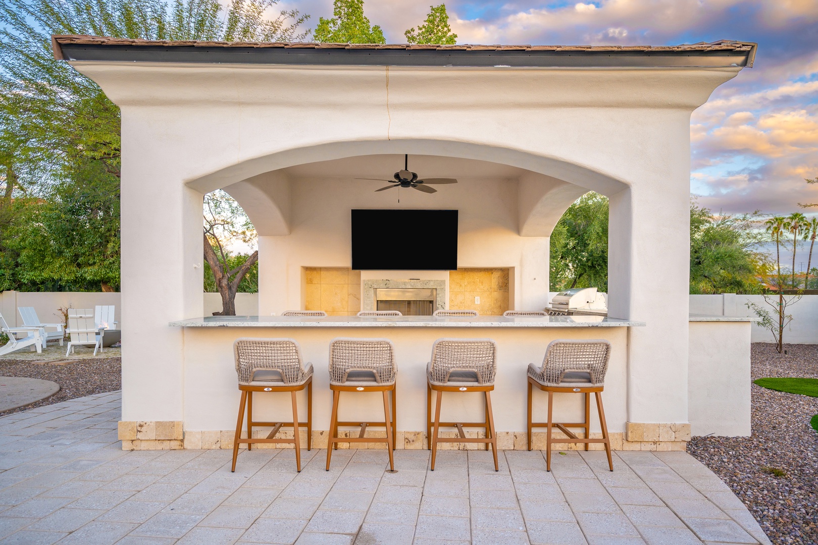 Gather at your private outdoor bar under the elegant archway, where tropical evenings feel effortless with a built-in grill, ambient lighting, and seating for casual sunset cocktails.