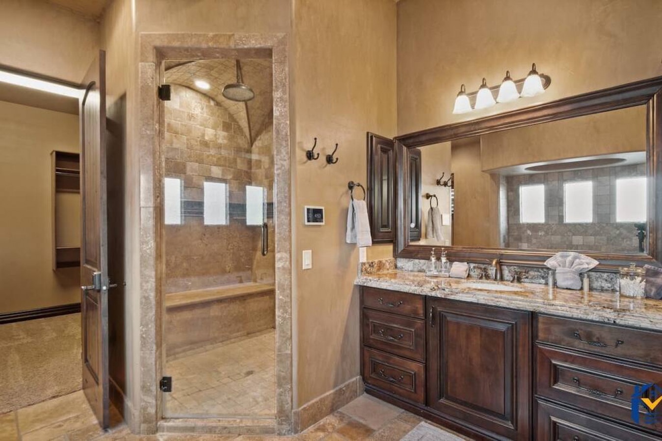 Indulge in your private spa-like bathroom featuring elegant stone finishes, spacious shower, and luxurious granite countertops with ample storage.