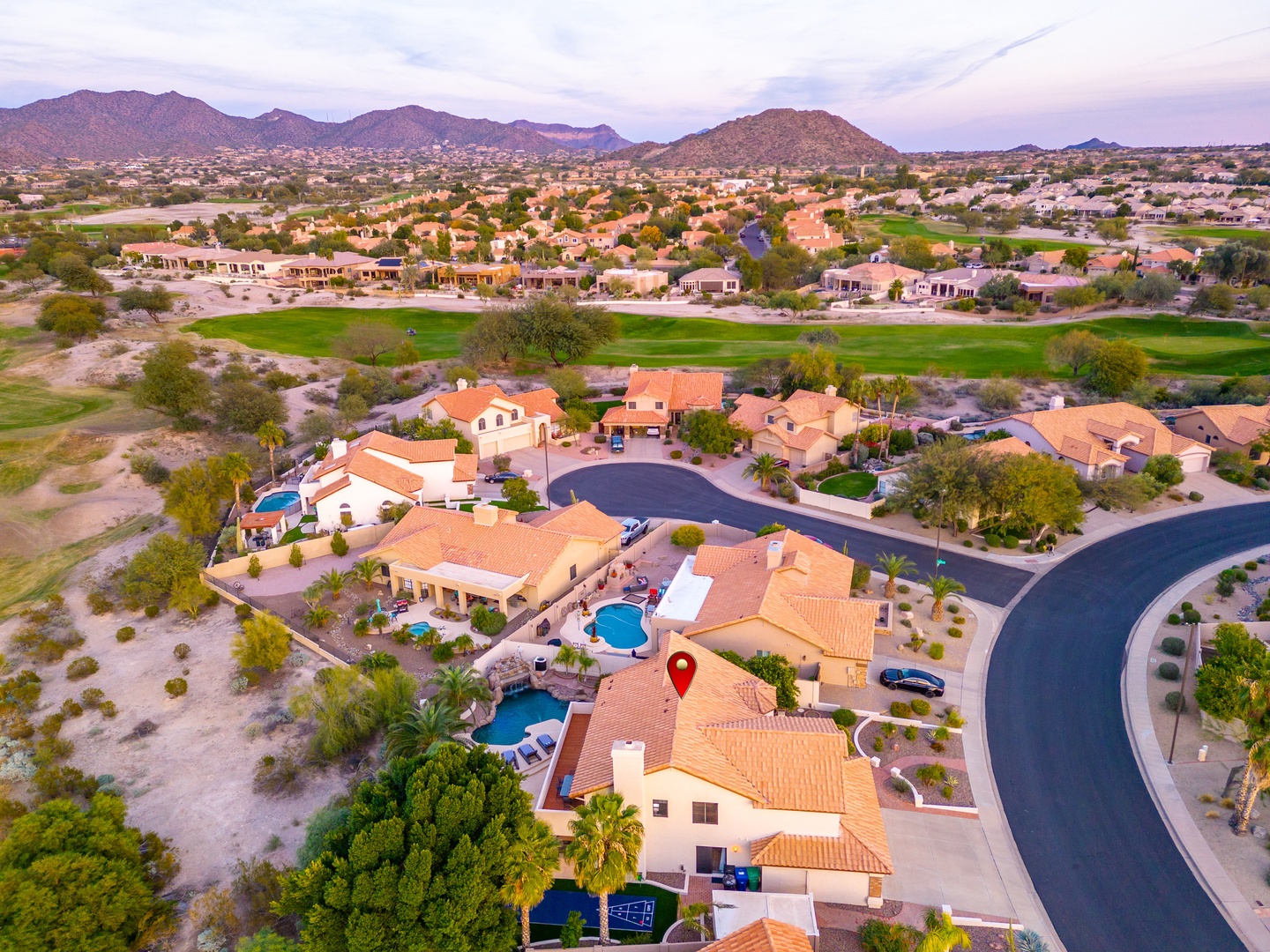 Aerial view of the property nestled in a peaceful desert golf community, surrounded by mountains, greens, and wide-open Southwestern skies.