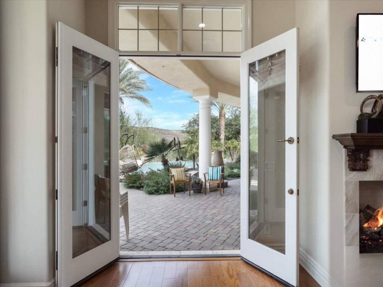 Open the doors to your private desert oasis, where a covered patio welcomes you to unwind in peaceful seclusion surrounded by lush palms and mountain views.