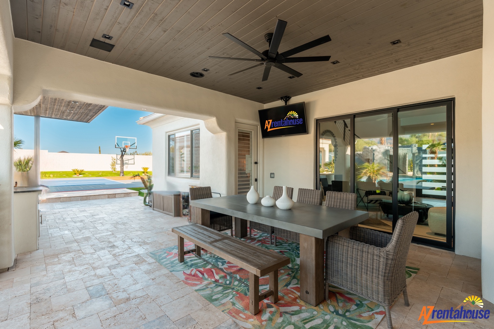 Your spacious covered terrace invites outdoor dining with elegant furnishings, cooling fans, and seamless pool views for perfect tropical evenings.