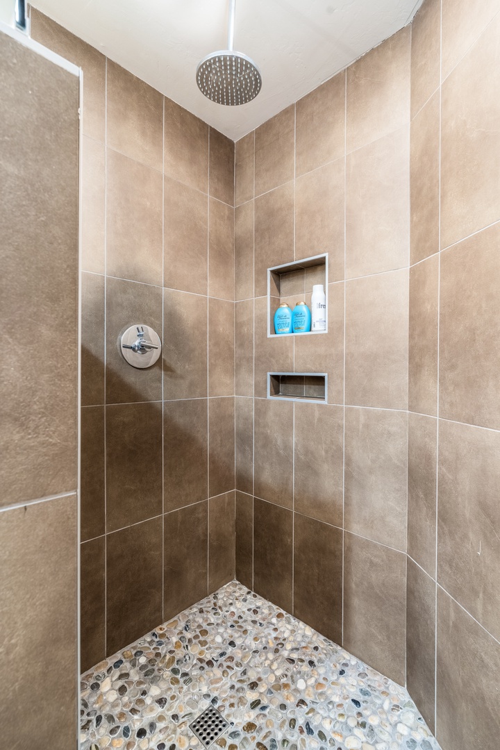 Step into your beautifully tiled walk-in shower, where a soothing rainfall showerhead and built-in niches for your essentials create a spa-like experience every morning.