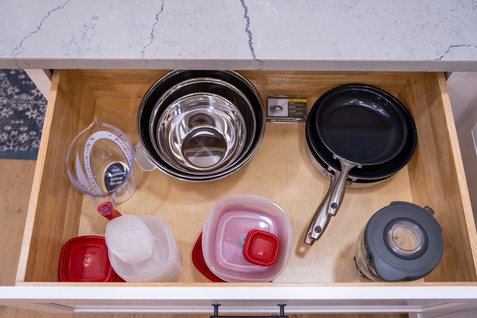 Your fully stocked kitchen drawer features nesting bowls, a non-stick skillet, measuring cups, and food storage containers—everything you need to prepare delicious home-cooked meals during your stay.