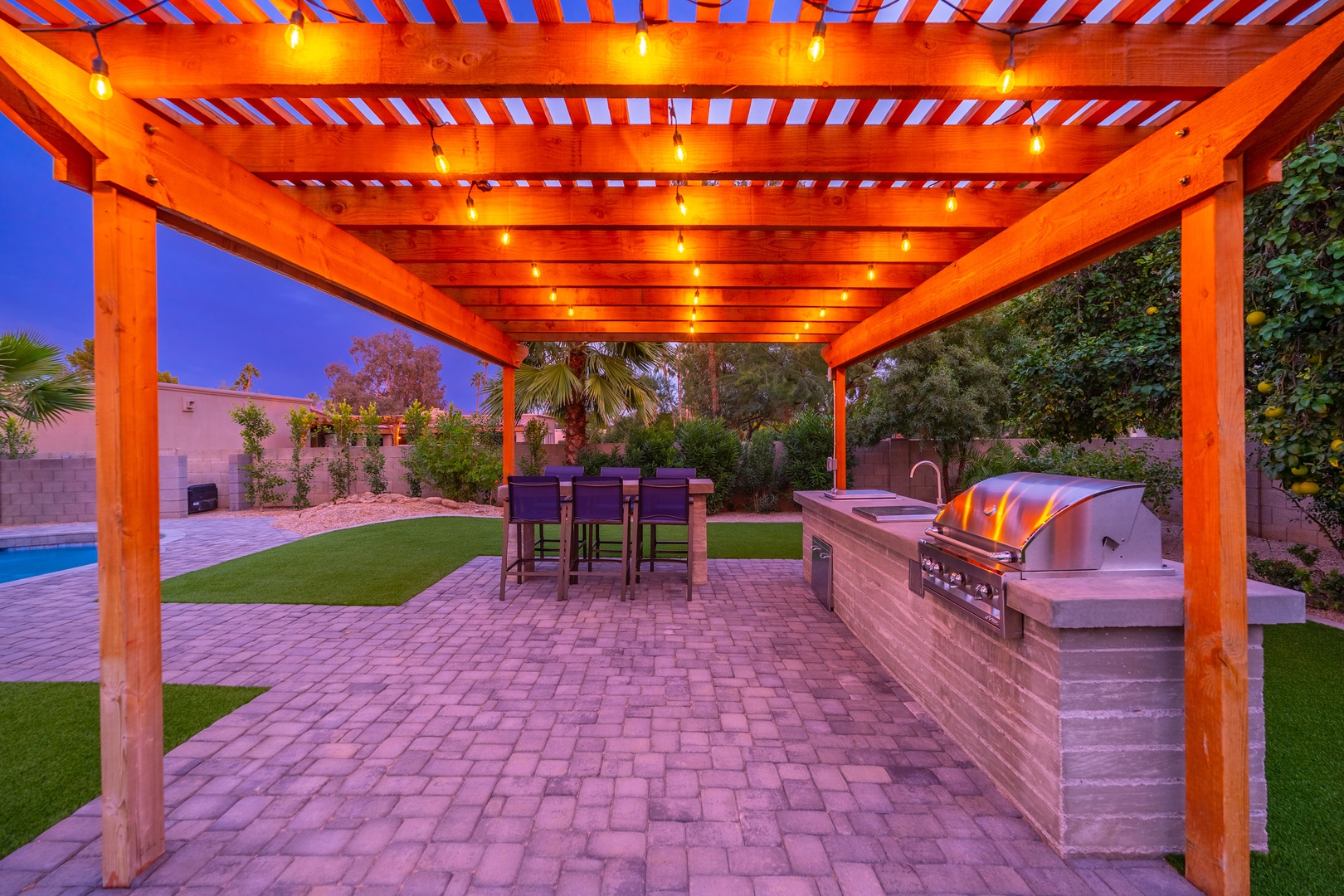 Gather under the glow of string lights in your private outdoor kitchen. Fire up the built-in grill, dine alfresco, and enjoy balmy desert evenings surrounded by lush greenery and modern comfort.