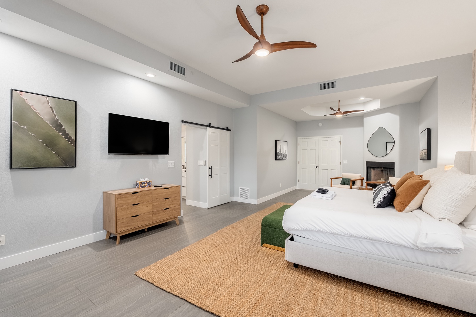Sink into your plush king bed in this spacious, light-filled suite featuring modern ceiling fans, stylish decor, and a soothing neutral palette designed for ultimate relaxation.
