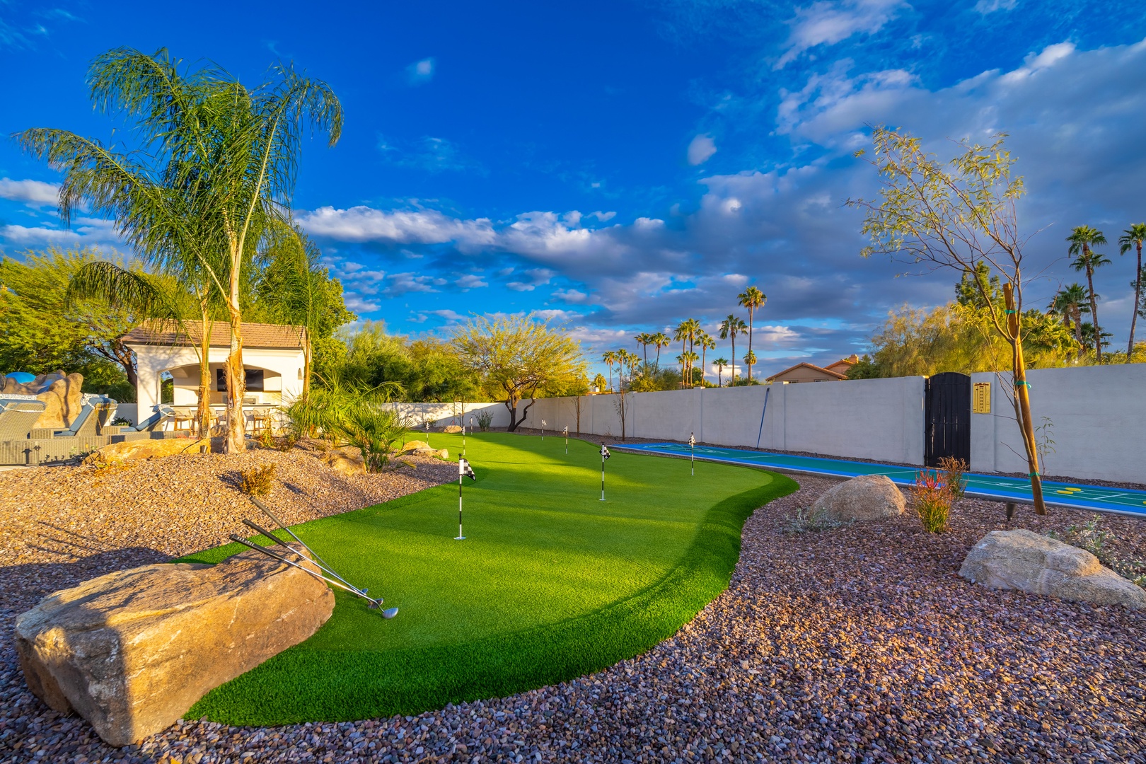 Perfect your putting game on this private miniature golf course, surrounded by lush palm trees and desert landscaping under sunny Arizona skies. A backyard oasis designed for fun and relaxation.